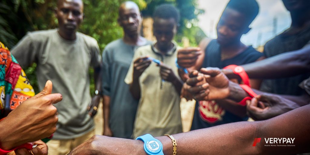 Several people standing in a circle holding VeryPay NFC cards and wearing NFC bracelets