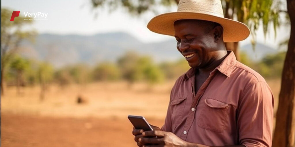 Photo showing a man wearing a wide-brimmed hat and smiling at his phone